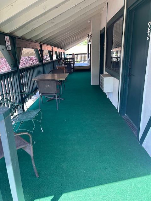 Covered front porch of The 10th Green Inn with green awning
